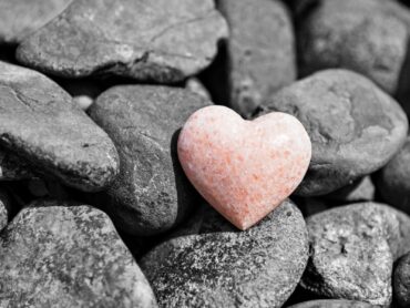 pietra a forma di cuore in mezzo a tante altre pietre ordinarie
